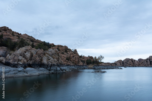 long exposure of The Dells rock formations at Watson Lake in Prescott, Arizona on a gray sky morning with dramatic clouds © ejkrouse