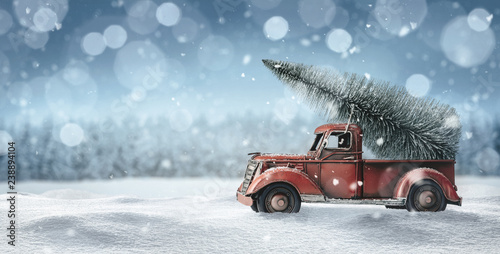 Photo Old red toy truck with christmas tree loaded on the back