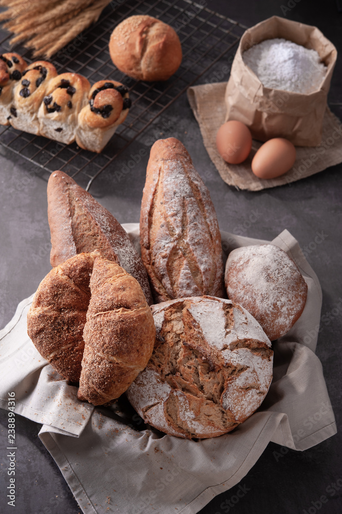 Homemade traditional bread with eggs and bag of flour on gray background