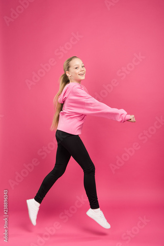 adorable blonde child dancing isolated on pink © LIGHTFIELD STUDIOS