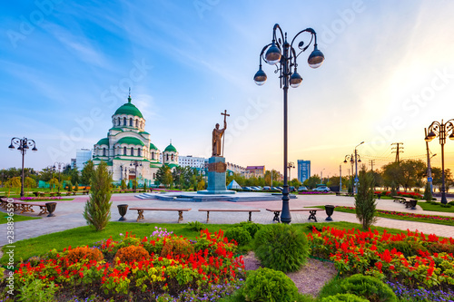 Beautiful colorful square in front of the Christian church in the city center during sunset with blue yellow sky. Monument to Saint Vladimir the Baptist and Vladimir Cathedral, Astrakhan, Russia. photo