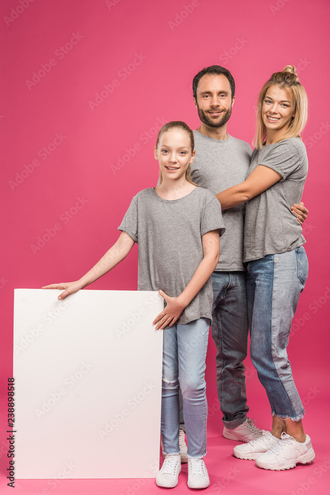 beautiful family posing with empty placard, isolated on pink beautiful family posing with empty placard, isolated on pink