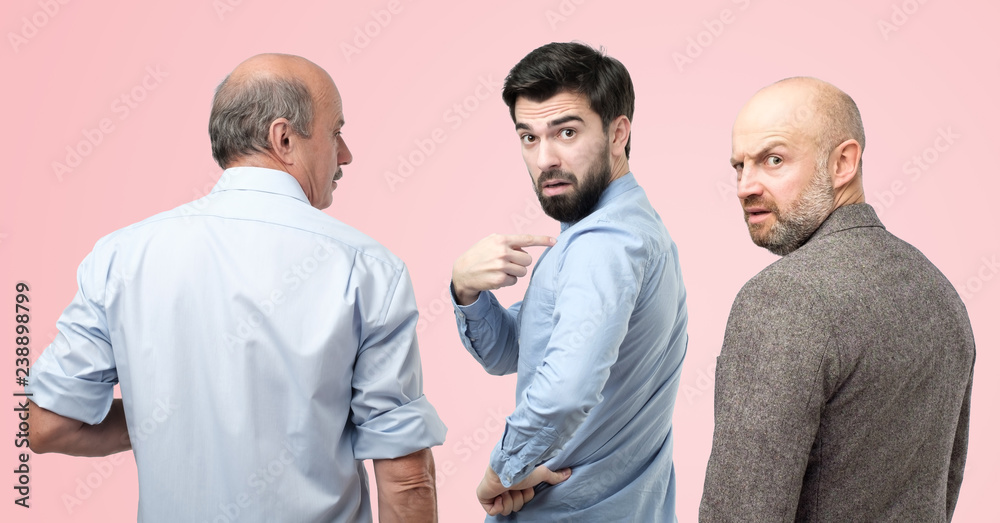 Are you talking about me concept. Horizontal portrait of three man, having doubtful confused uncertain facial expression Are you talking about me concept. Horizontal portrait of three man, having doubtful confused uncertain facial expression