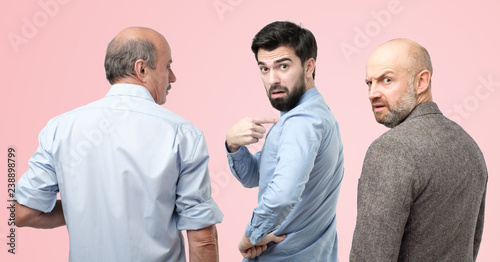 Are you talking about me concept. Horizontal portrait of three man, having doubtful confused uncertain facial expression