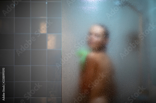Photography Woman taking a long hot shower washing her hair in a modern design bathroom