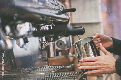Fotografía Hand hält an Kaffeemaschine Kännchen mit Milch zum aufschäumen