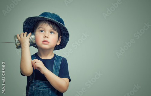 Little boy holding a can with a cord