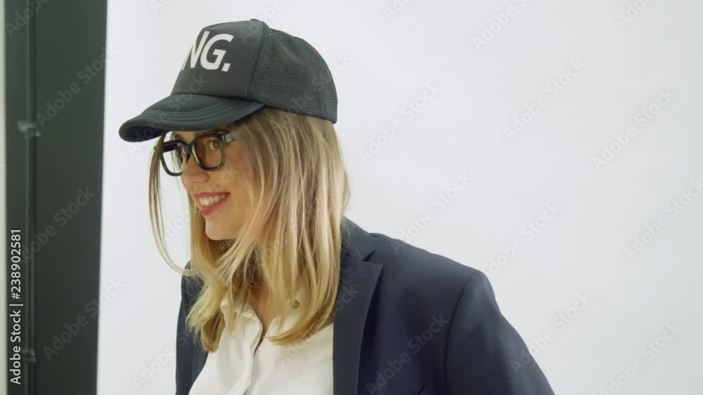 Model in black baseball cap and balck jacket poses during photoshoot