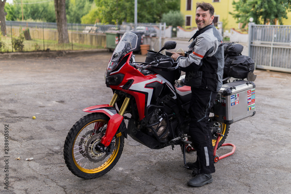 Portrait of smiling man preparing for a motorbike trip Portrait of smiling man preparing for a motorbike trip