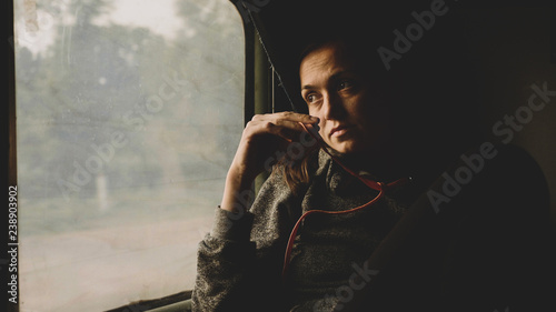 Vintage style image of young women looking out of window in asian train