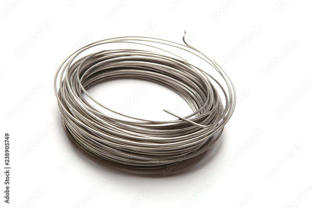 Coil of stainless steel wire isolated on white background. Stack of stainless steel metal wire. Coil of stainless steel wire isolated on white background. Stack of stainless steel metal wire.