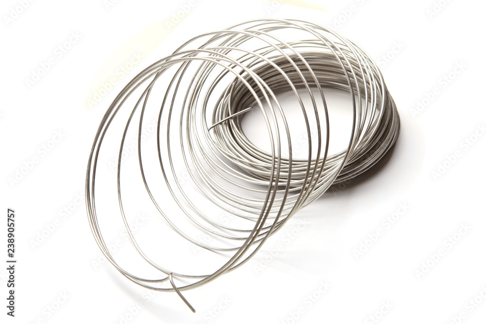 Coil of stainless steel wire isolated on white background. Stack of stainless steel metal wire. Coil of stainless steel wire isolated on white background. Stack of stainless steel metal wire.