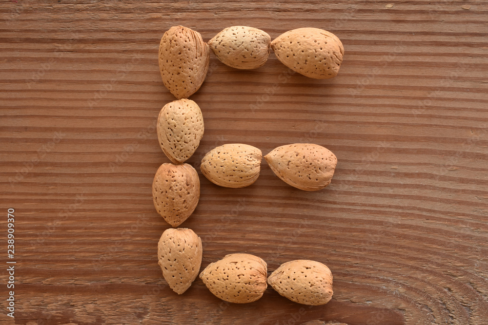 the letter E shaped with almonds on wood the letter E shaped with almonds on wood
