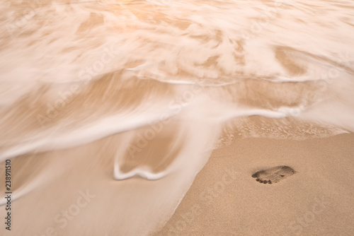 sea wave move to erase human footprint on beach