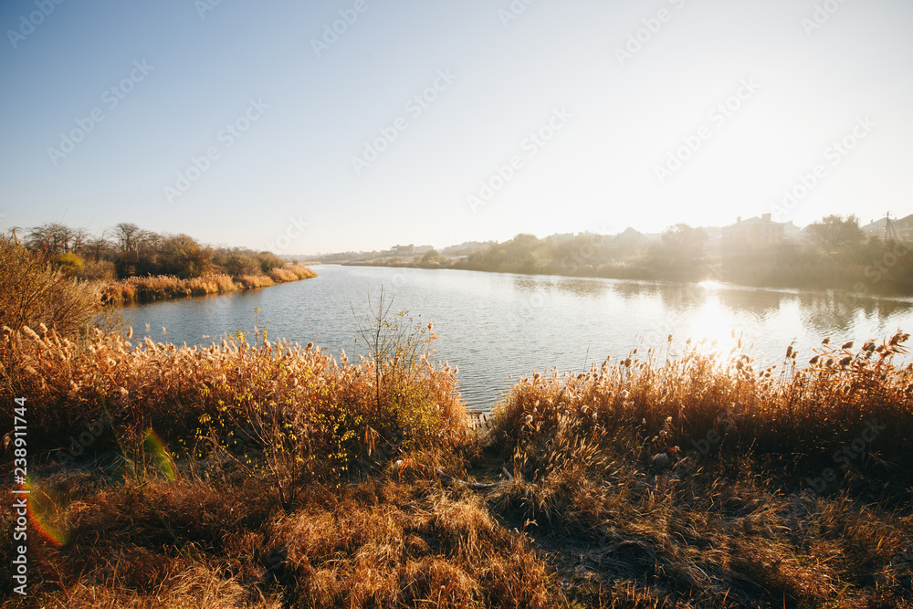 Early morning. Beautiful, colorful autumn lake in sunlight rays. Autumn background