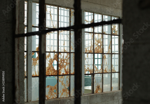 old broken windows viewed through window frame in jail