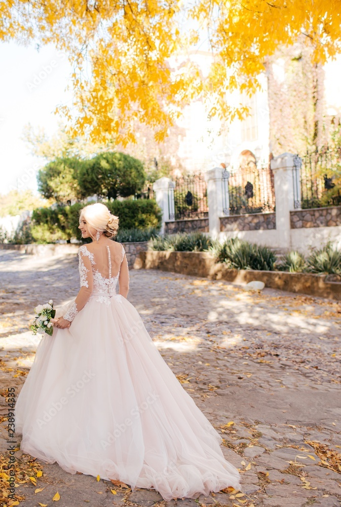 Beautiful blonde bride in white dress in the garden Beautiful blonde bride in white dress in the garden