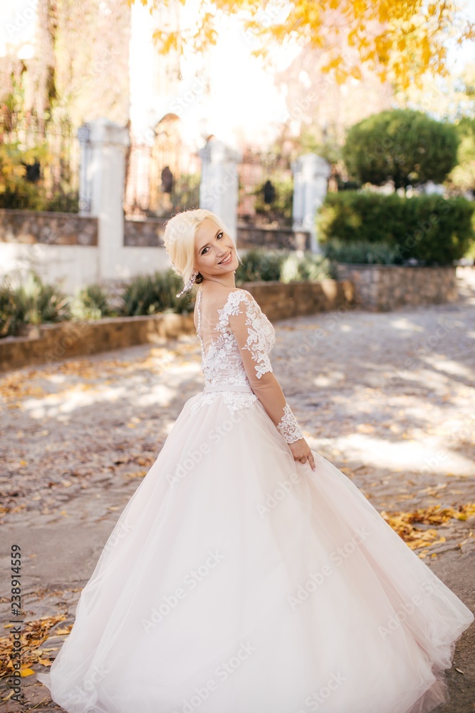 Beautiful blonde bride in white dress in the garden Beautiful blonde bride in white dress in the garden