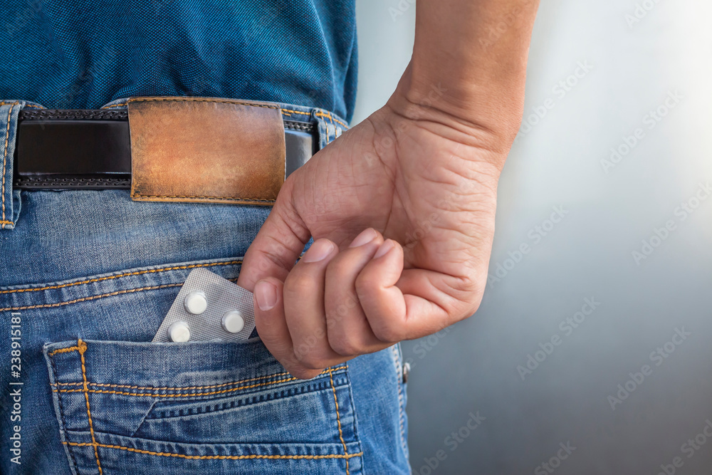 Men hand pulls tablet pills of jeans pocket. Medical, health care concept.  You forgot to take medicine. Stock Photo | Adobe Stock