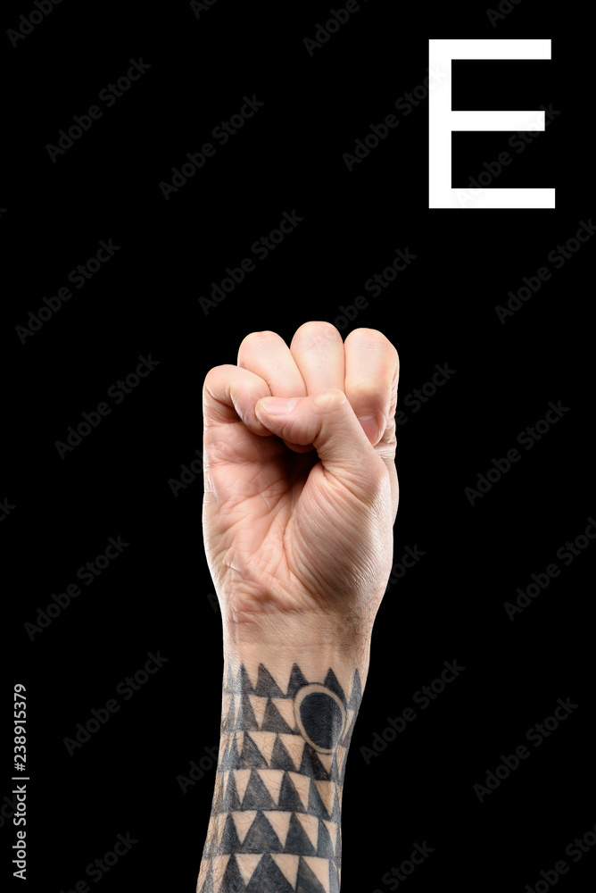 tattooed male hand showing latin letter - E, sign language, isolated on  black Stock Photo | Adobe Stock