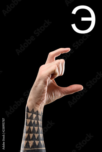 cropped view of male tattooed hand showing cyrillic letter, deaf and dumb language, isolated on black