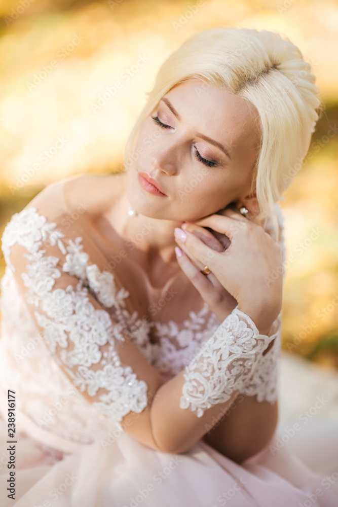 Beautiful blonde bride in white dress in the garden Beautiful blonde bride in white dress in the garden