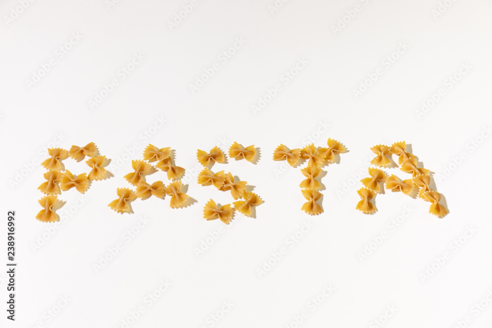 Text made with Italian pasta, farfalle, white background