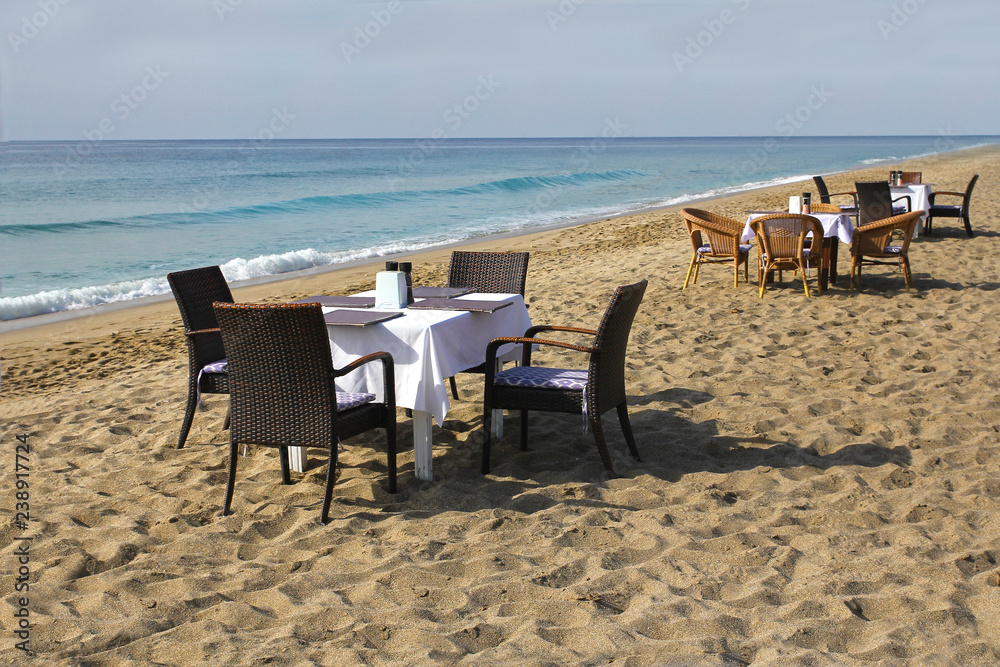 Table and chairs on the beach by the sea. Romantic concept. Marine Cafe.