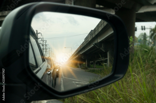 Side view of car mirror traffic of rear-end vehicles on the road with Bridges.