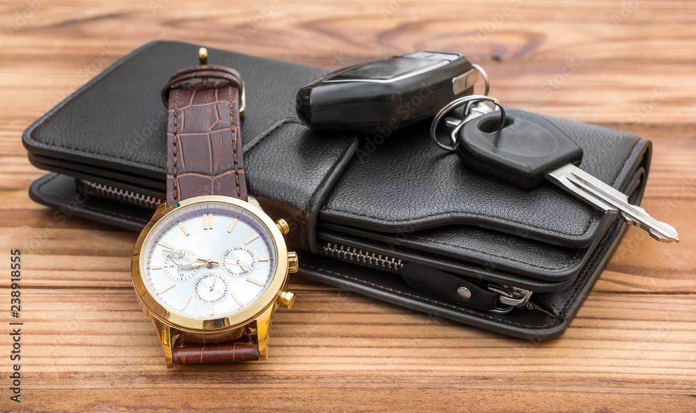 Wrist watch, wallet and car key on wooden table. Stock-Foto | Adobe Stock