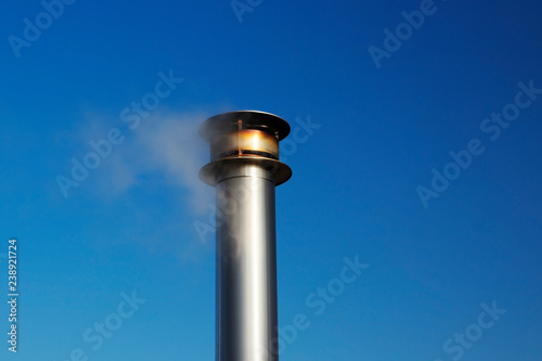 Smoke comes from the chimney of the house. Winter heating, ecology concept.