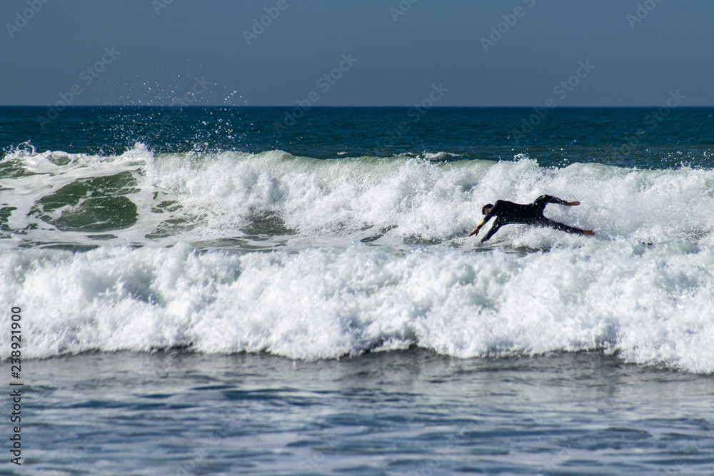 Surfing wipe out as male surf boarder dives into the breaking waves