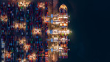 Crane shipping container at night, Aerial top view container ship carrying container import and export business logistic and transportation.