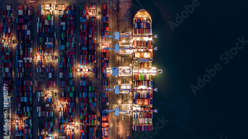 Crane shipping container at night, Aerial top view container ship carrying container import and export business logistic and transportation. © Kalyakan