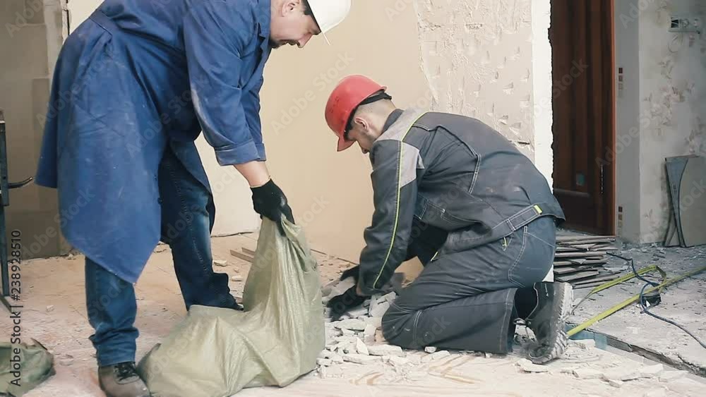 A worker is putting soil debris in a bag A worker is putting soil debris in a bag