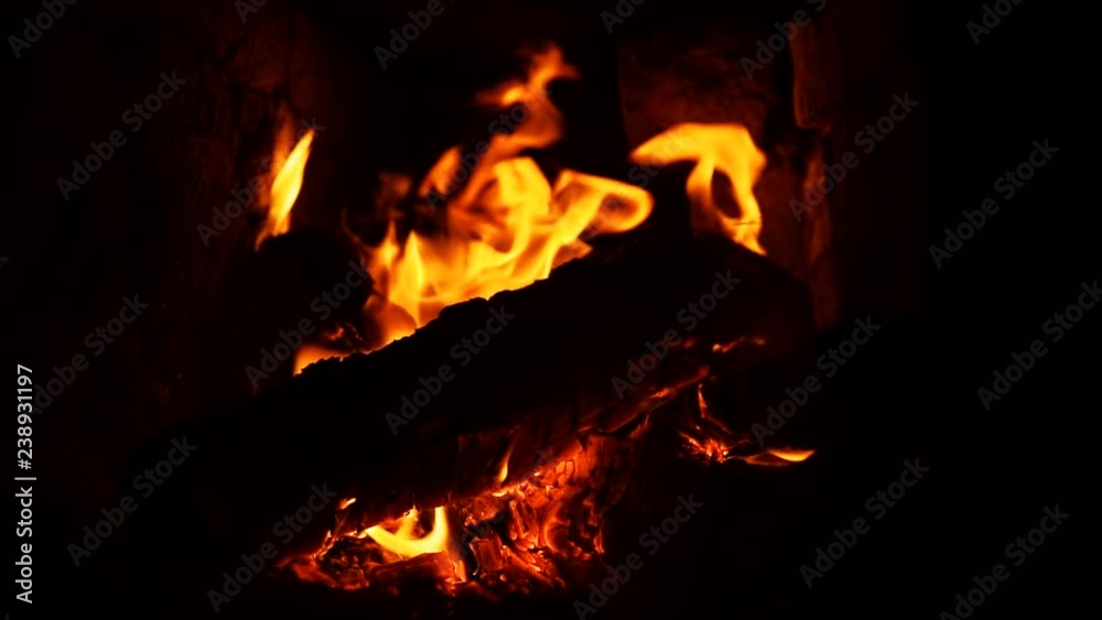 Close-up shot of hot fireplace full of dry firewood, warm cozy burning fire in a brick furnace, slow motion. Close-up shot of hot fireplace full of dry firewood, warm cozy burning fire in a brick furnace, slow motion.