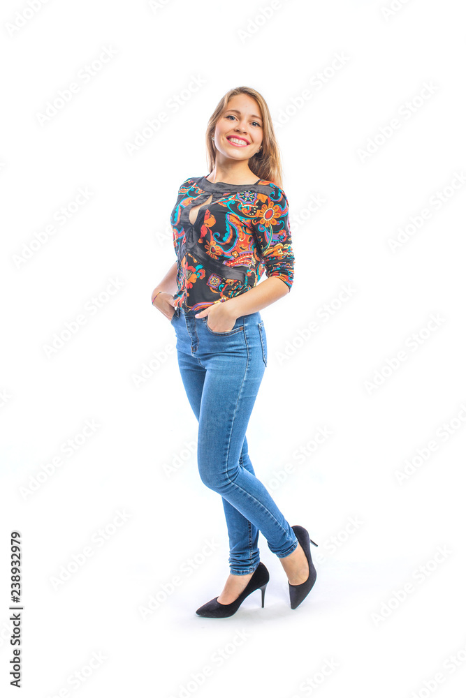 Attractive young woman with long blond hair in jeans, a blouse and shoes posing at the camera in profile with her hands in the pockets of jeans smiling. Attractive young woman with long blond hair in jeans, a blouse and shoes posing at the camera in profile with her hands in the pockets of jeans smiling.