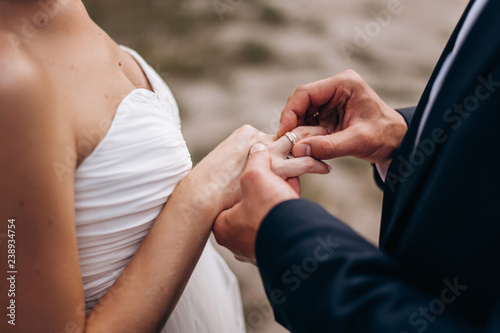 the groom wears a wedding ring on the bride's finger during the wedding ceremony