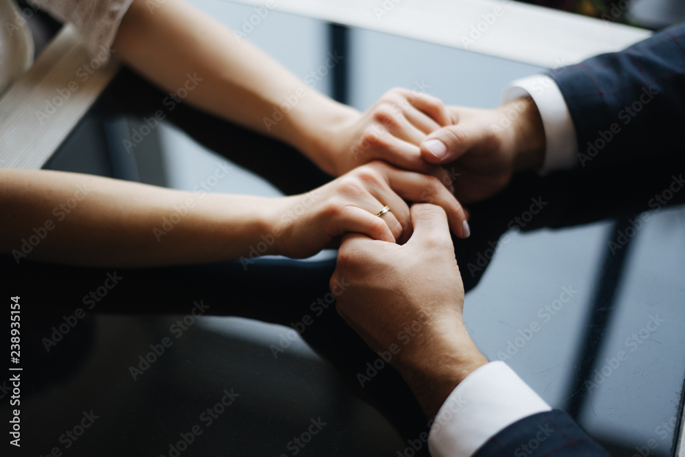 hands of couple on background of dark table