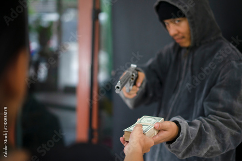 Gun and money in a hands. Bank robbery, Man carrying a gun to rob the money. To threaten with the gun man photo