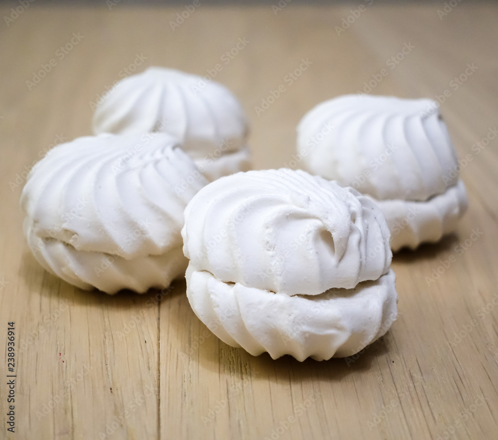 four zephyr (marshmallows) on a wooden table
