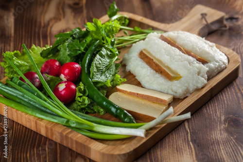 Mengrelian corn mamalica (ghomi) with cheese and various herb on wooden table. Georgian traditional food photo