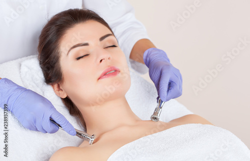 The cosmetologist makes the procedure Microdermabrasion of skin of a beautiful, young woman in a beauty salon.Cosmetology and professional skin care.