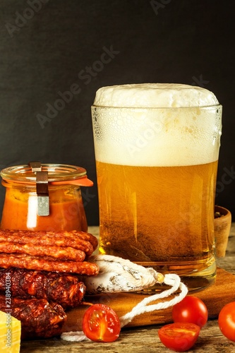 Beer and sausages on an old wooden table. Sale of beer and sausage. Food for beer. Unhealthy food.