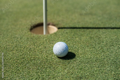 Golf field with white ball near the hole
