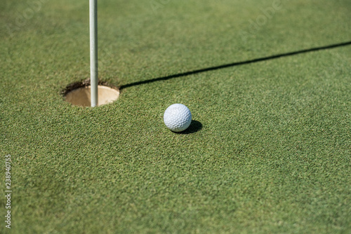 Golf field with white ball near the hole