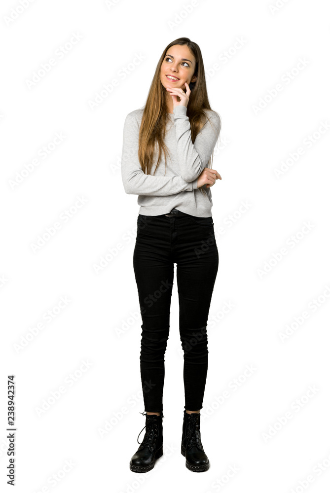 Full-length shot of young girl thinking an idea while looking up on isolated white background Full-length shot of young girl thinking an idea while looking up on isolated white background