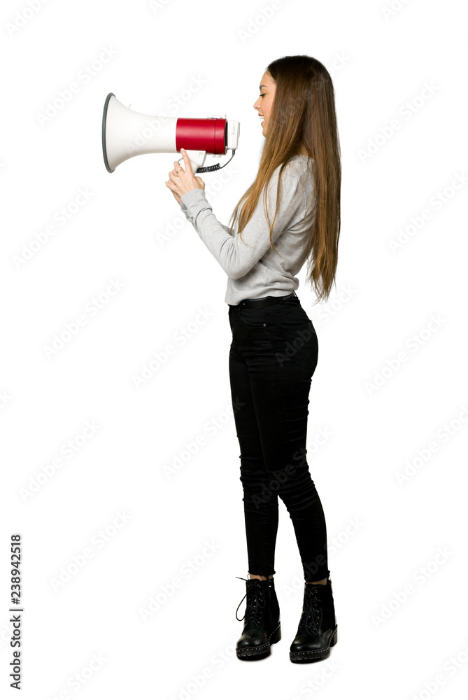 Full-length shot of young girl shouting through a megaphone to announce something in lateral position on isolated white background Full-length shot of young girl shouting through a megaphone to announce something in lateral position on isolated white background