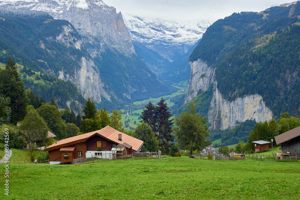 Mountain dramatic valley view with wooden rustic house in Wengen in Lauterbrunnen region in Switzerland.