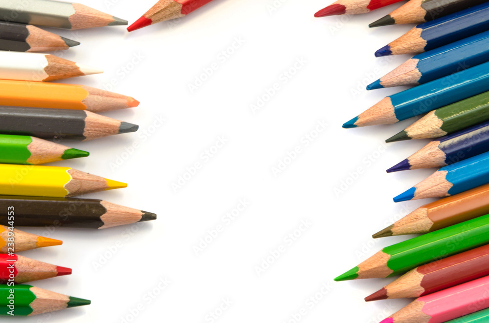 Color pencils pink light blue green yellow and red on white background.